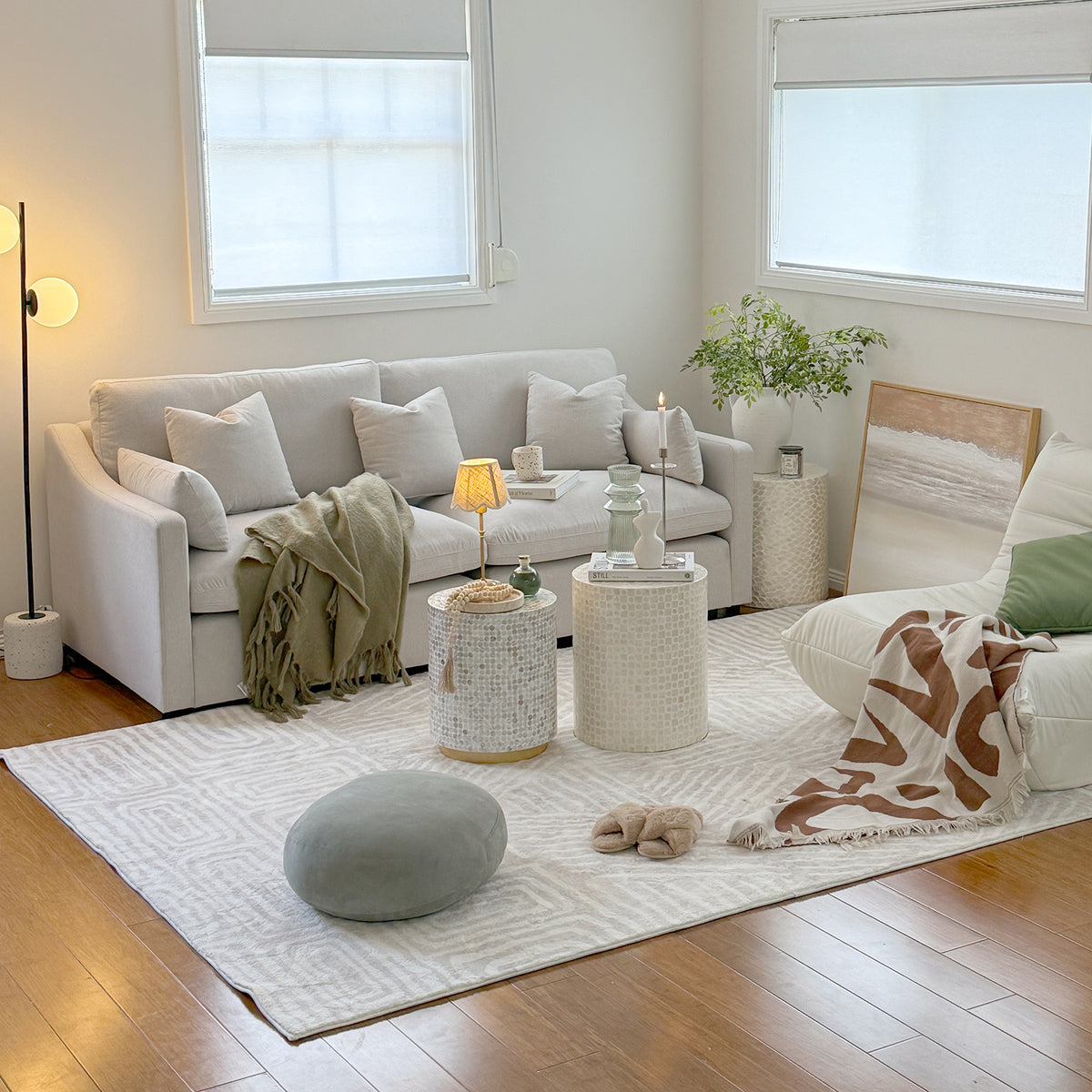 Modern living room with white sofa, armchair, ottoman, and neutral decor
