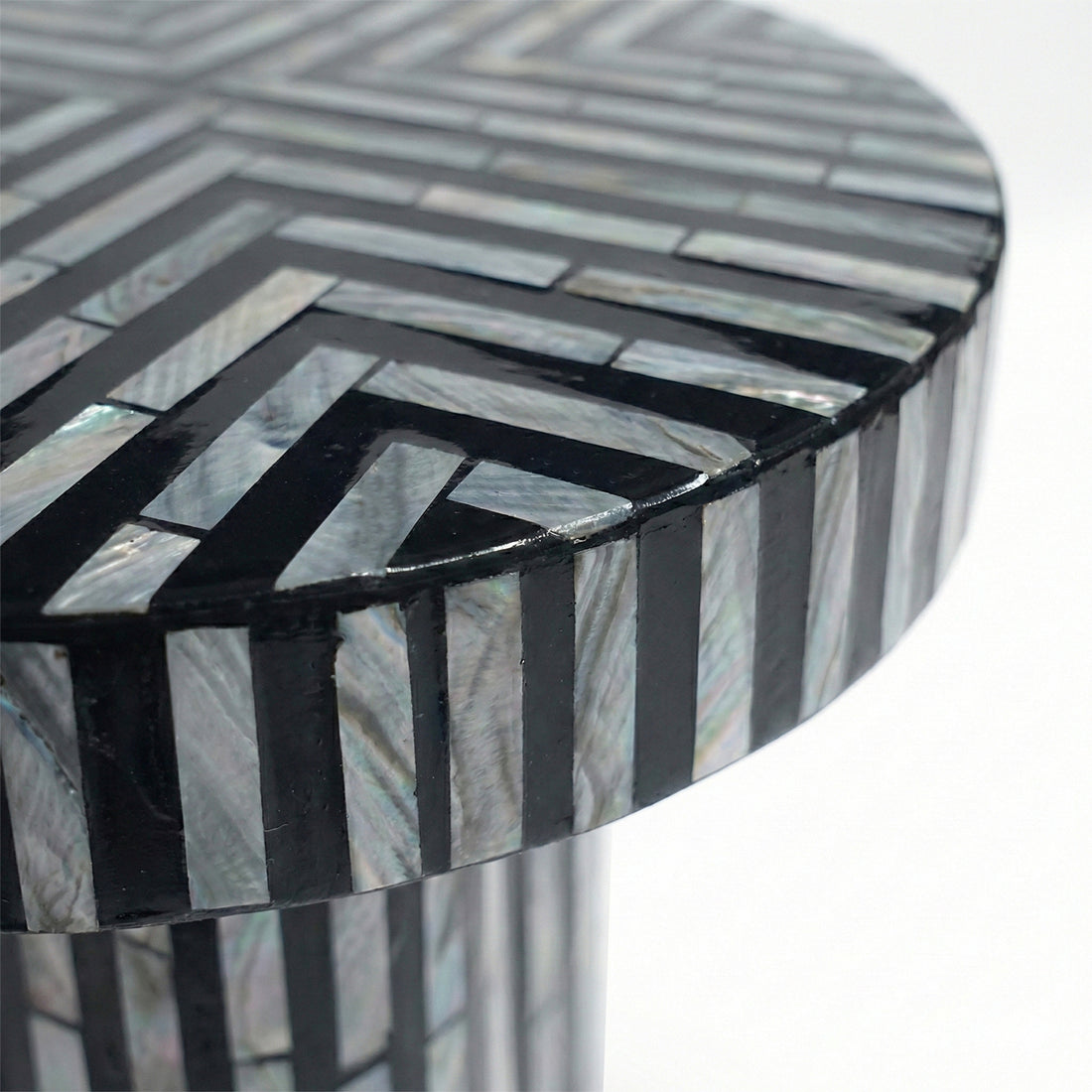 Extreme close-up of geometric inlay pattern on table top against white background