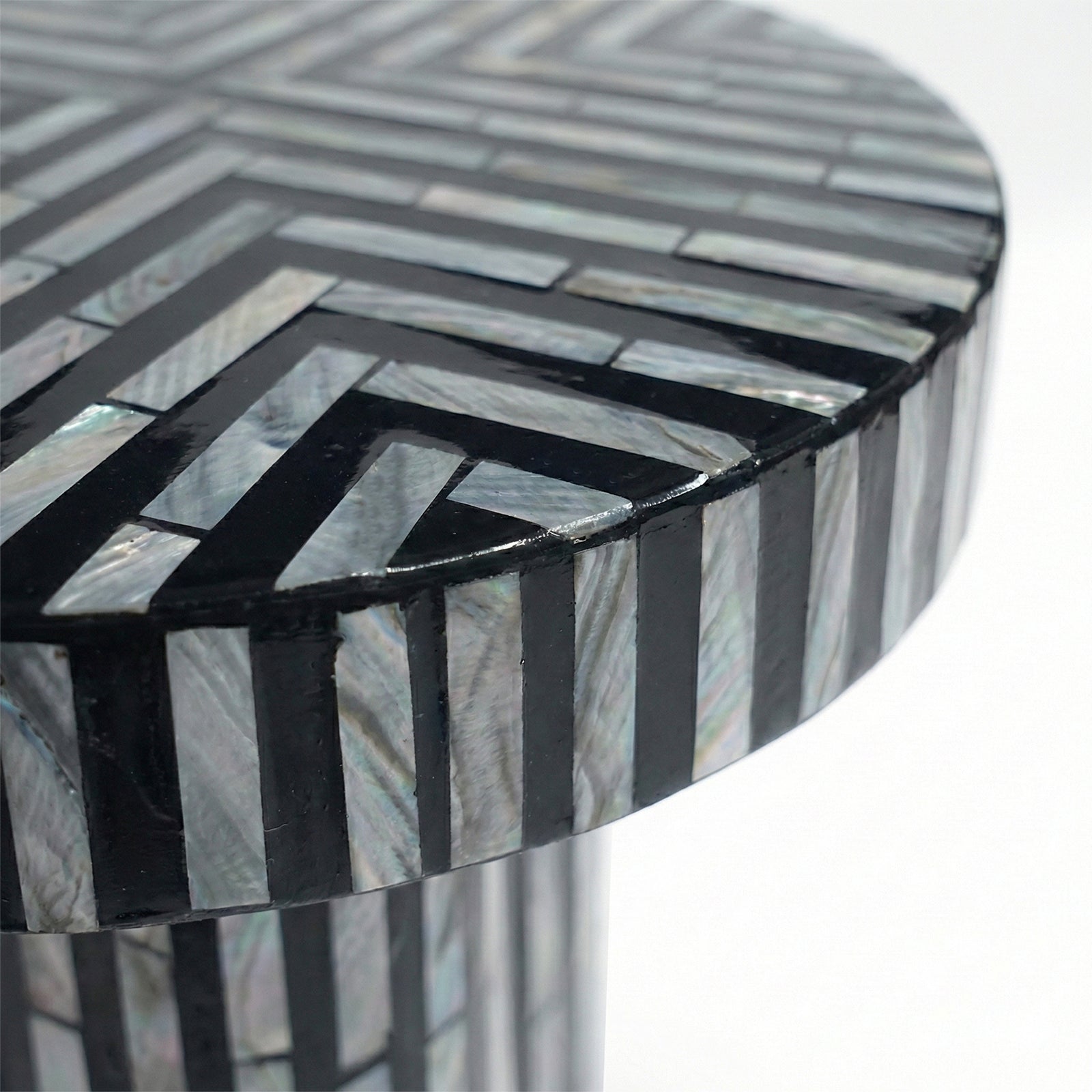 Extreme close-up of geometric inlay pattern on table top against white background