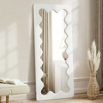 Serena 180cm Full Length Mirror in Cream White with a scalloped edge frame, leaning against a wall, surrounded by a bench, open book, wicker vase, and pampas grass for a minimalist look.