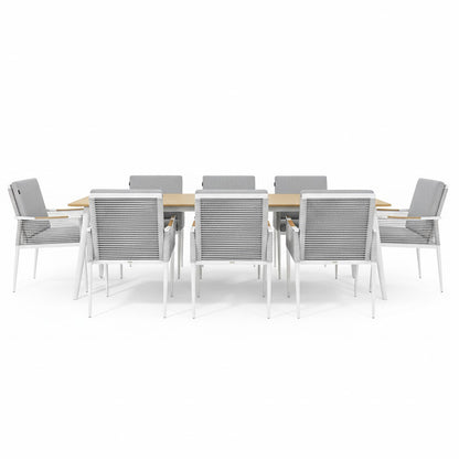 Casara 9 Piece Outdoor Dining Set in White and Grey: Light-wood table with slatted top, eight armchairs featuring white metal frames, gray woven sides, and cushioned seats, designed for alfresco dining.