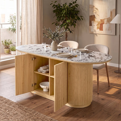 Modern oval dining table with marble-look top and light wood base in a stylish dining room