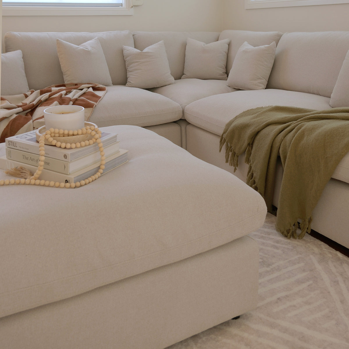 Beige sectional sofa with ottoman styled in a living room