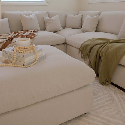 Beige sectional sofa with ottoman styled in a living room