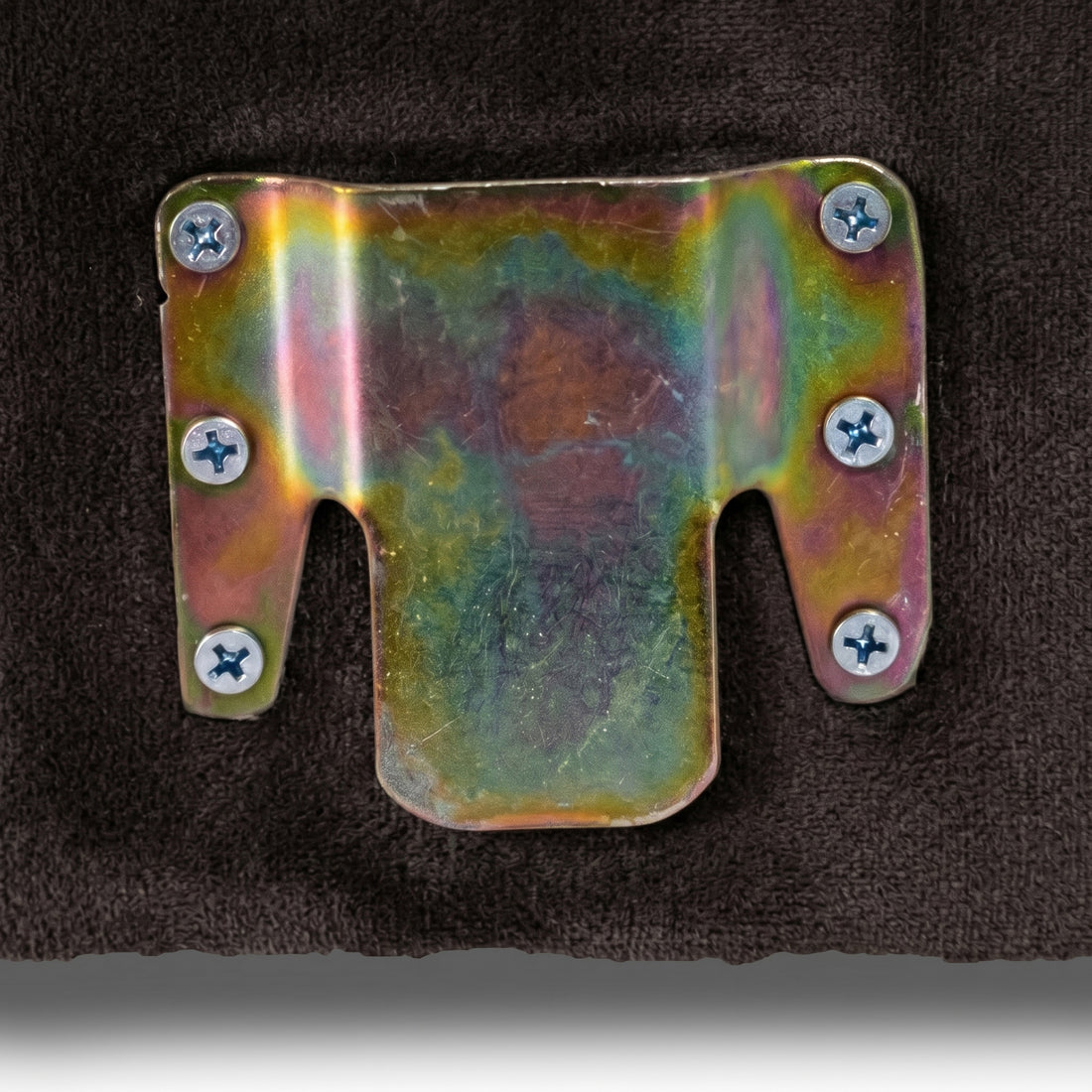 Close-up of metal bracket detail on dark surface