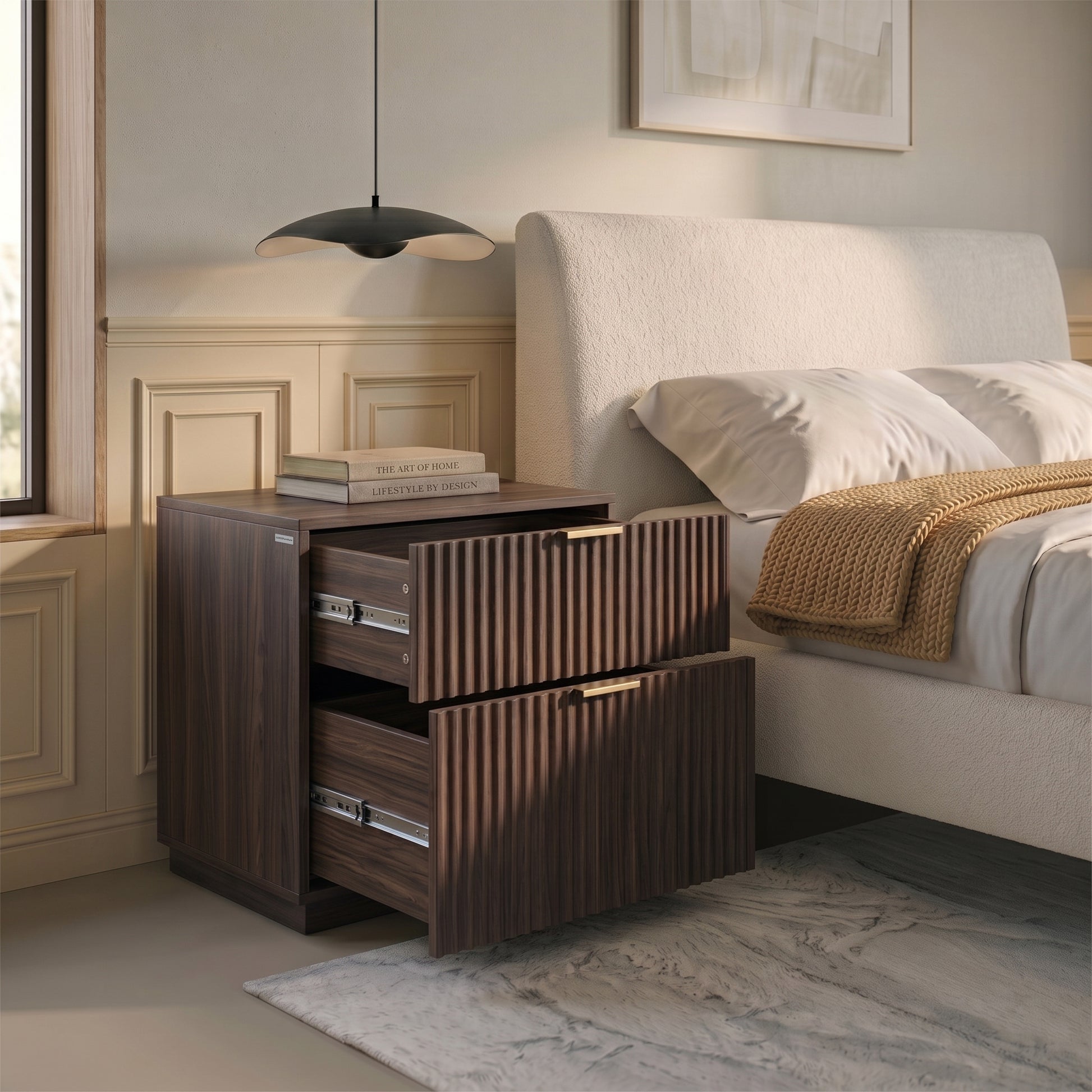 Walnut nightstand beside a bed in a bedroom with books and decor