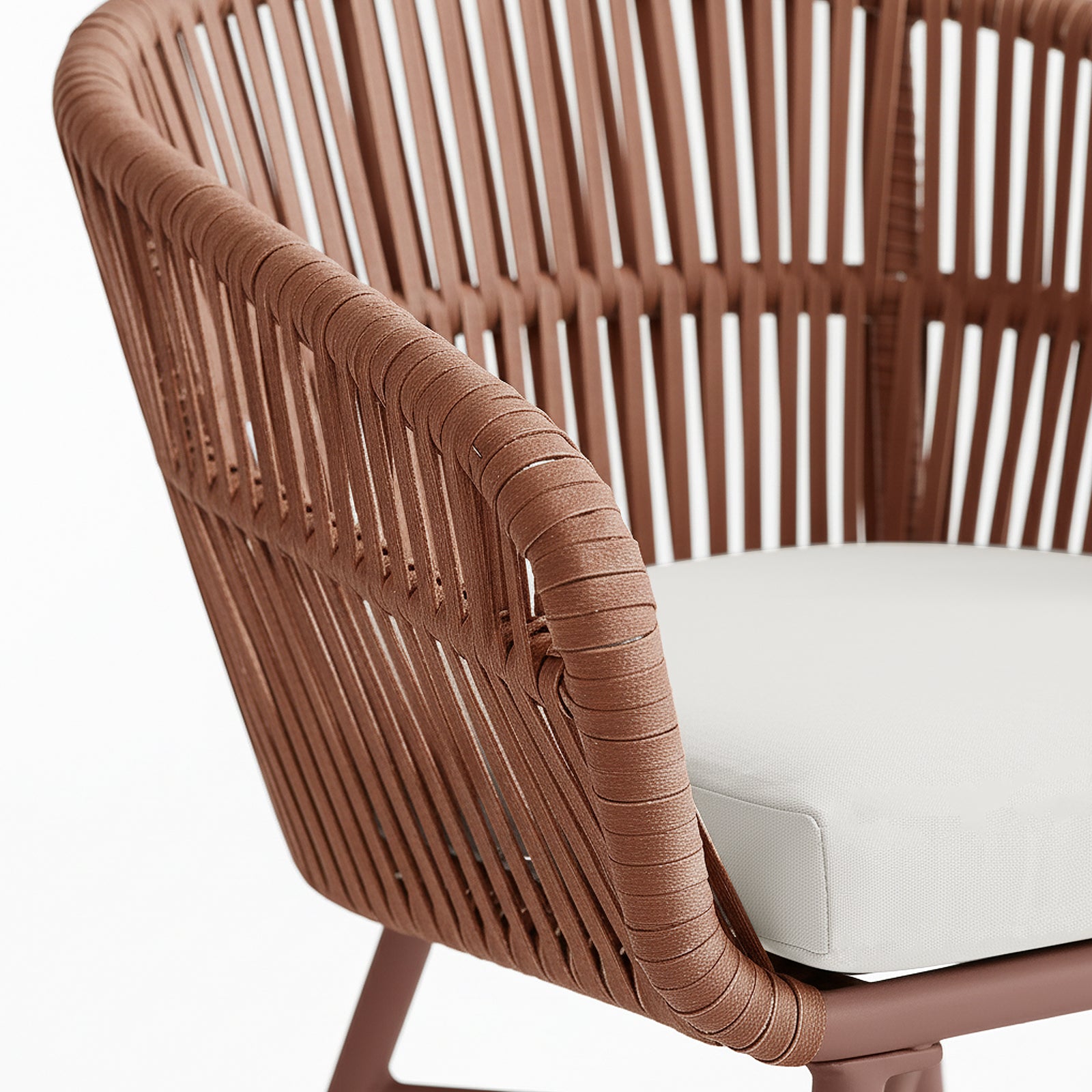 Close-up of Marula Rope Outdoor Dining Chairs in Terracotta Set of 4, highlighting the tubular metal frame with rust-brown rope forming the back and armrest, and a light-cream cushion on the seat.