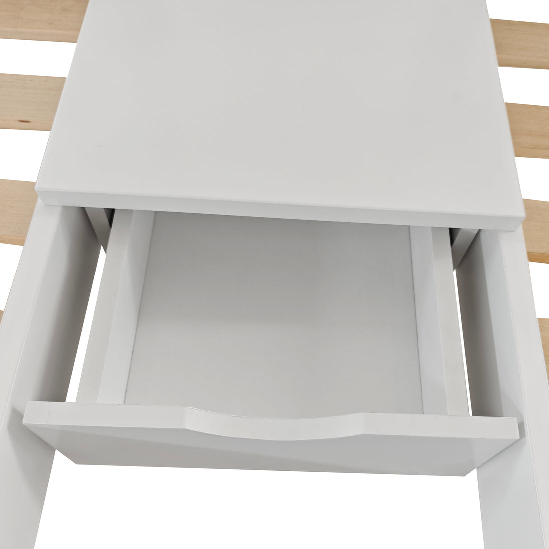 Aristos Triple Bunk Bed with Side Table in White features a partially open white storage drawer with a curved handle, suggesting integration into a larger furniture piece.