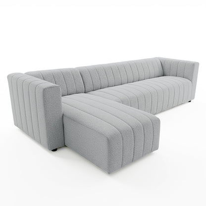 Parisa 4 Seater Tufted Boucle Sofa with Chaise in Light Grey, featuring a modern L-shape, low profile, squared arms, vertical channel tufting, and plush bouclé upholstery for a cozy, inviting look.