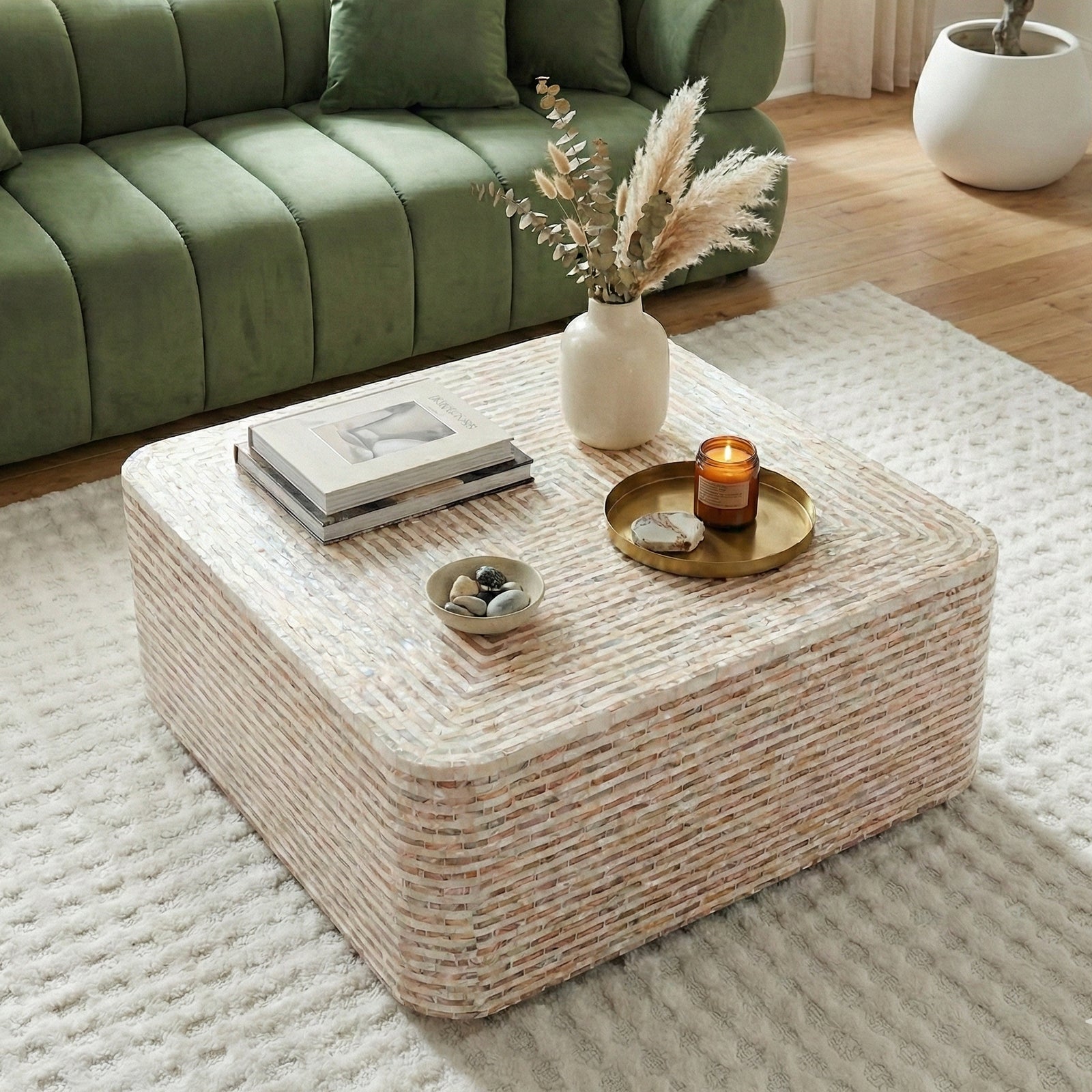 Woven coffee table styled in a modern living room with books and vase