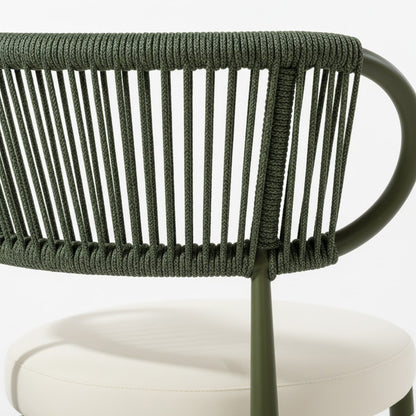 Cabria 7 Piece Sintered Stone Outdoor Dining Set in Green features an olive-green metal chair frame with woven rope backrest and light beige round padded seat cushion, showcasing modern coastal minimalism.