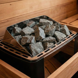 Sauna heater filled with stones inside a wooden sauna room