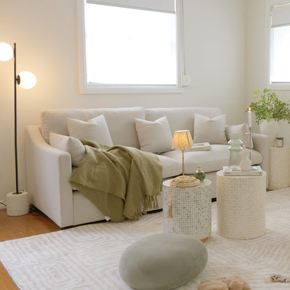 White sofa styled in a bright modern living room with decor and tables
