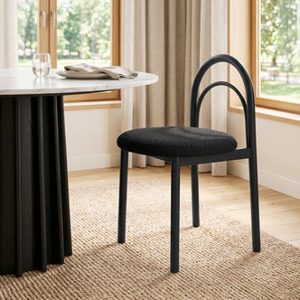 Modern black chair in a bright dining room next to a round table