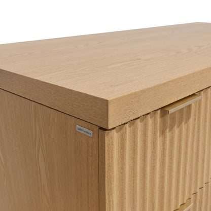 Close-up detail of a light wood cabinet corner and handle on white background