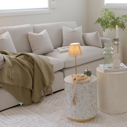 Styled living room corner with mosaic side tables, sofa, lamp, and decor