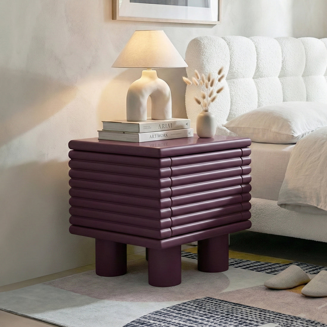 Burgundy ribbed nightstand beside bed in a styled bedroom