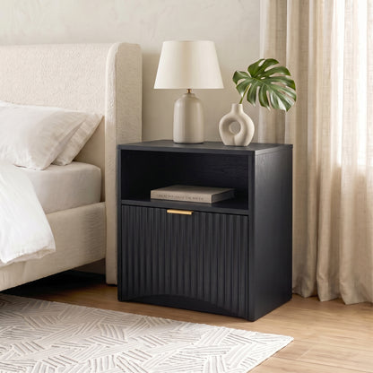 Black nightstand styled beside a bed in a bright modern bedroom