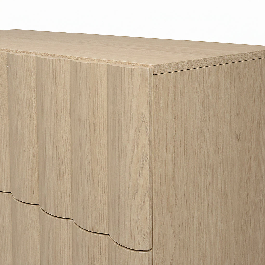 Close-up of the top corner of a light wood dresser on white background
