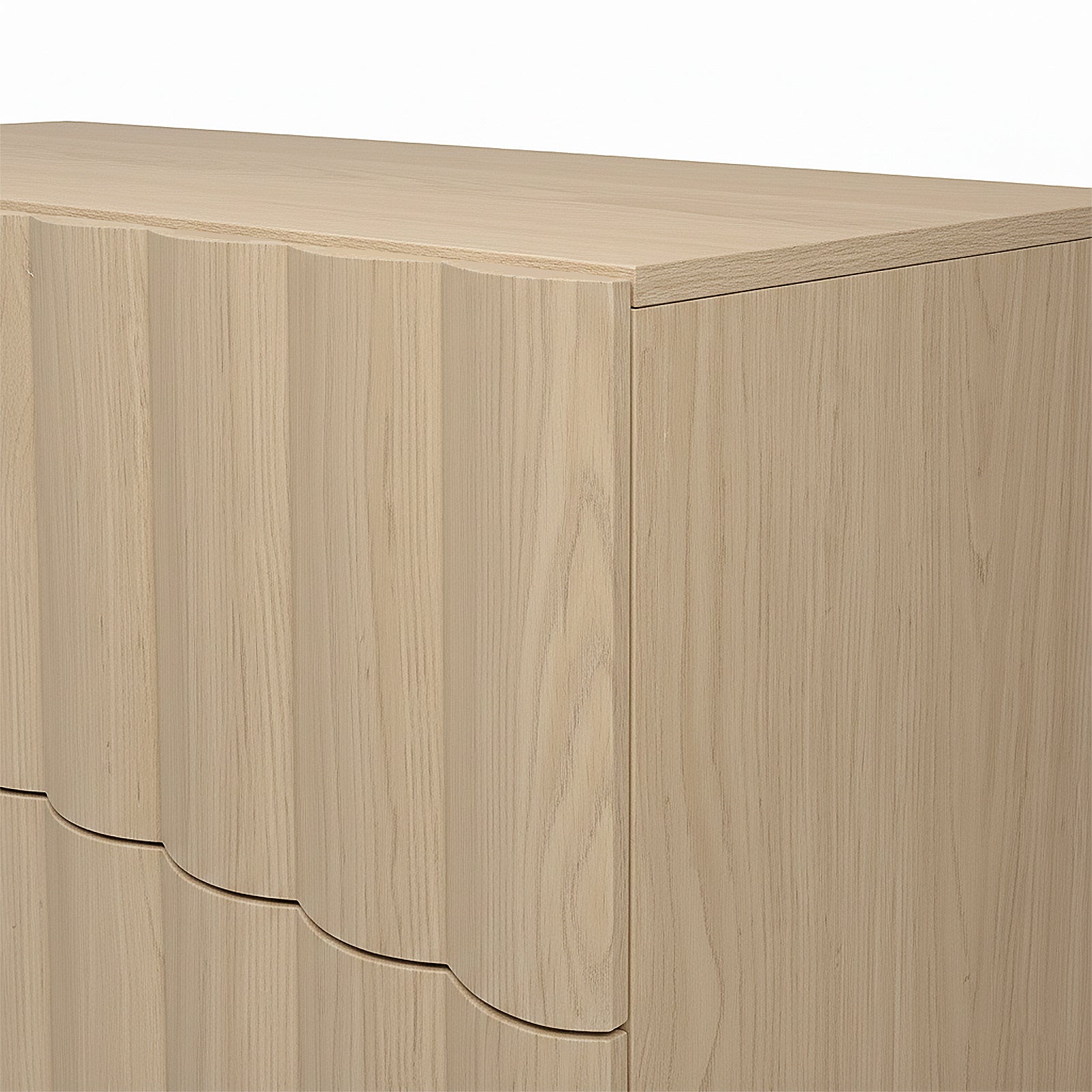 Close-up of the top corner of a light wood dresser on white background