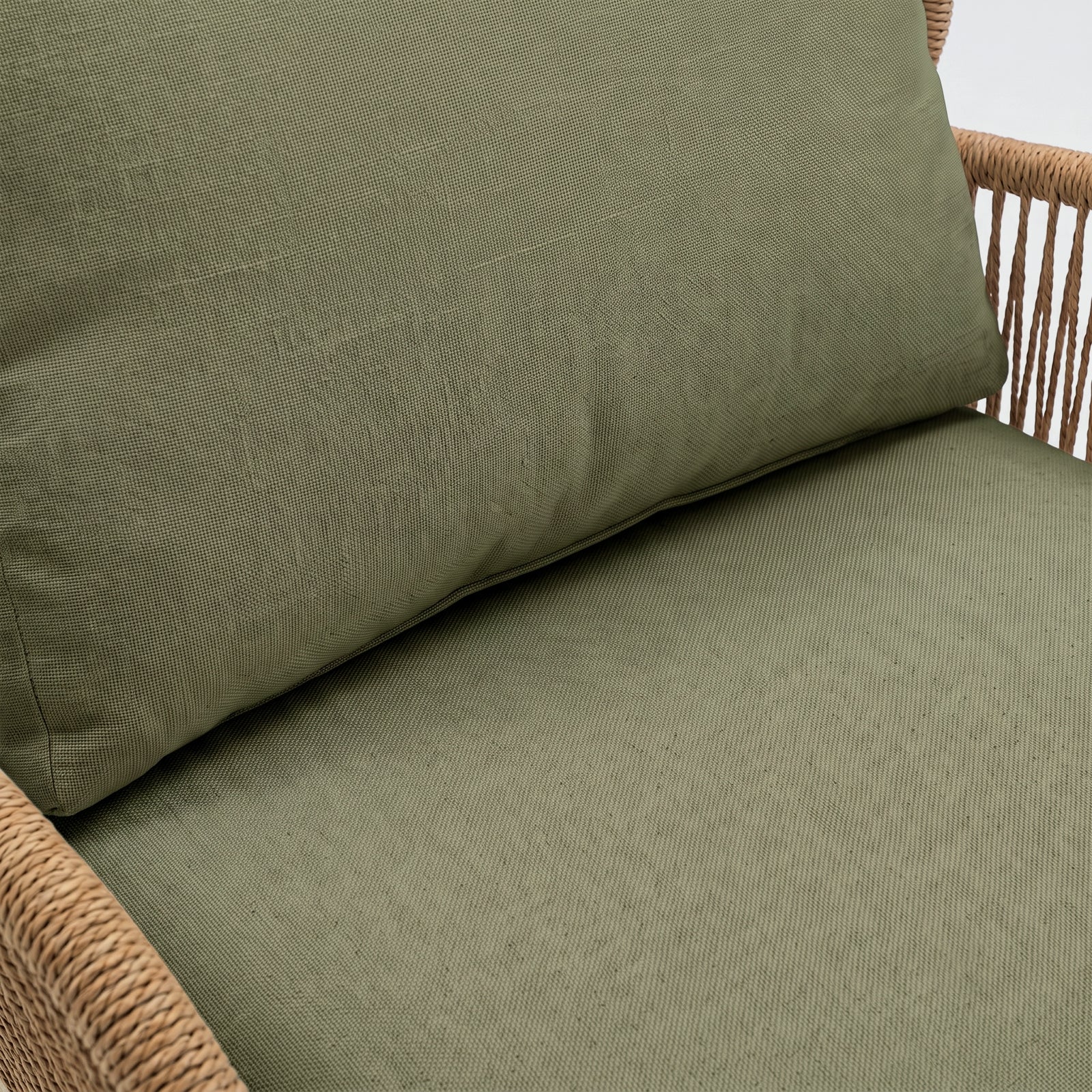 Close-up of chair seat and backrest with green cushion and woven frame detail