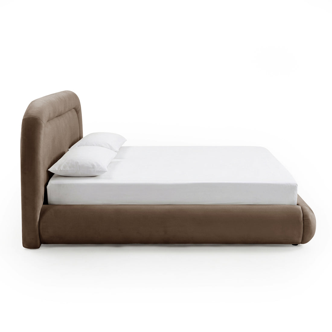 Side-angle view of a low-profile taupe upholstered bed with white bedding