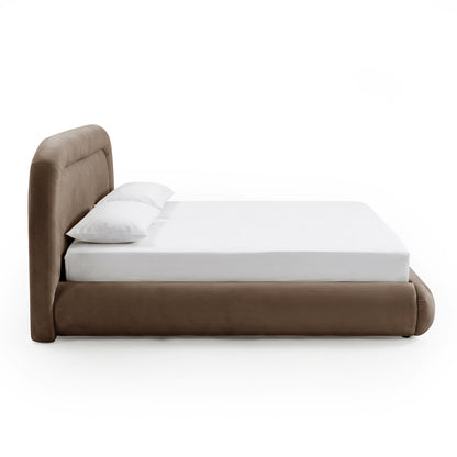 Side-angle view of a low-profile taupe upholstered bed with white bedding