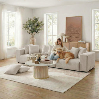 Beige sectional sofa in styled living room with woman and dog