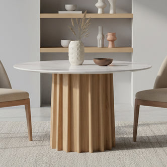 Gabi 120cm Marble Look Dining Table in Oak features a round marble-finish top, fluted wooden base, complemented by light upholstered chairs and a serene, minimalist dining nook setting.