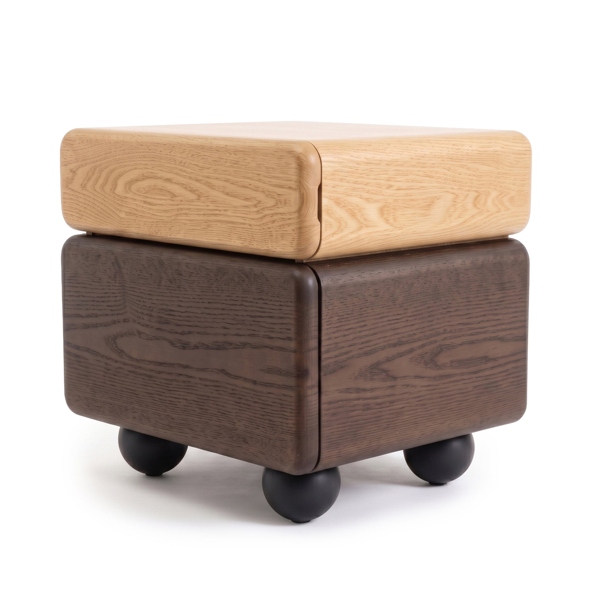 Cube-shaped two-tone wooden side table with black spherical feet on a white background