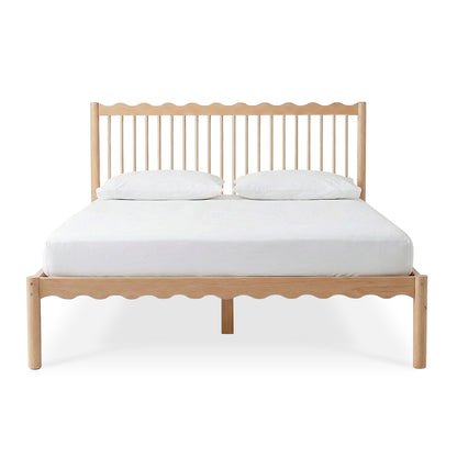 Front-facing wooden bed frame with wave-edge headboard and white bedding on white background