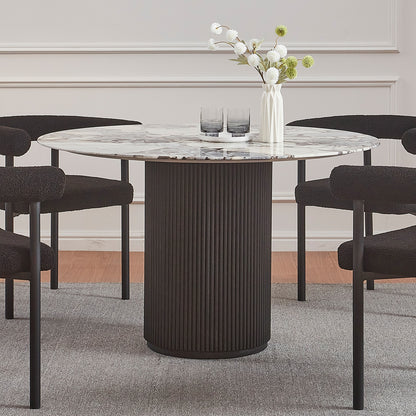 Gracie 120cm Round Marble Dining Table in Black features a marble top on a fluted black base, surrounded by four black chairs. A vase and tray adorn the tabletop.