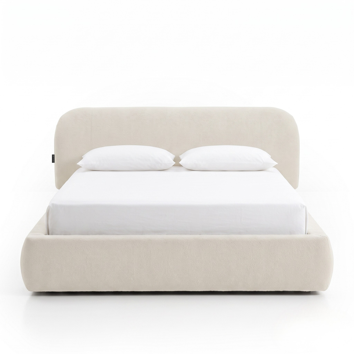 Modern upholstered bed with pillows on a white background