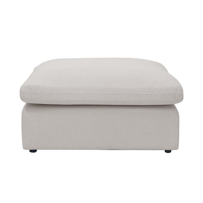 Light beige upholstered ottoman photographed on a white background
