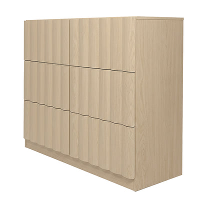 Angled view of light wood six-drawer dresser on white background