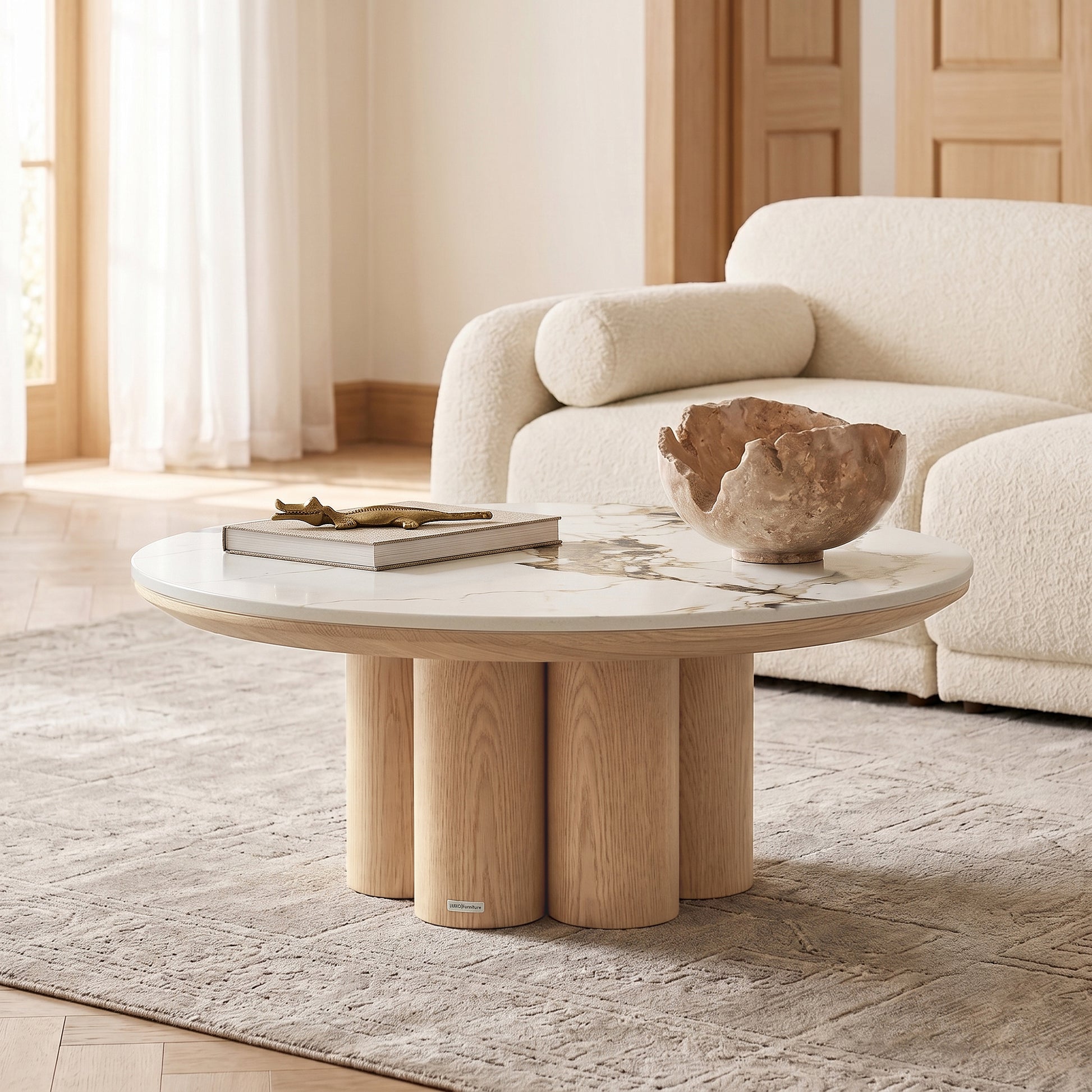 Round coffee table with light wood base and marble-look top styled in a modern living room