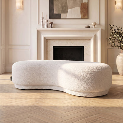 Curved cream white upholstered bench seat in a stylish living room