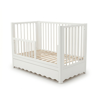Full view of white baby crib with storage drawer on white background