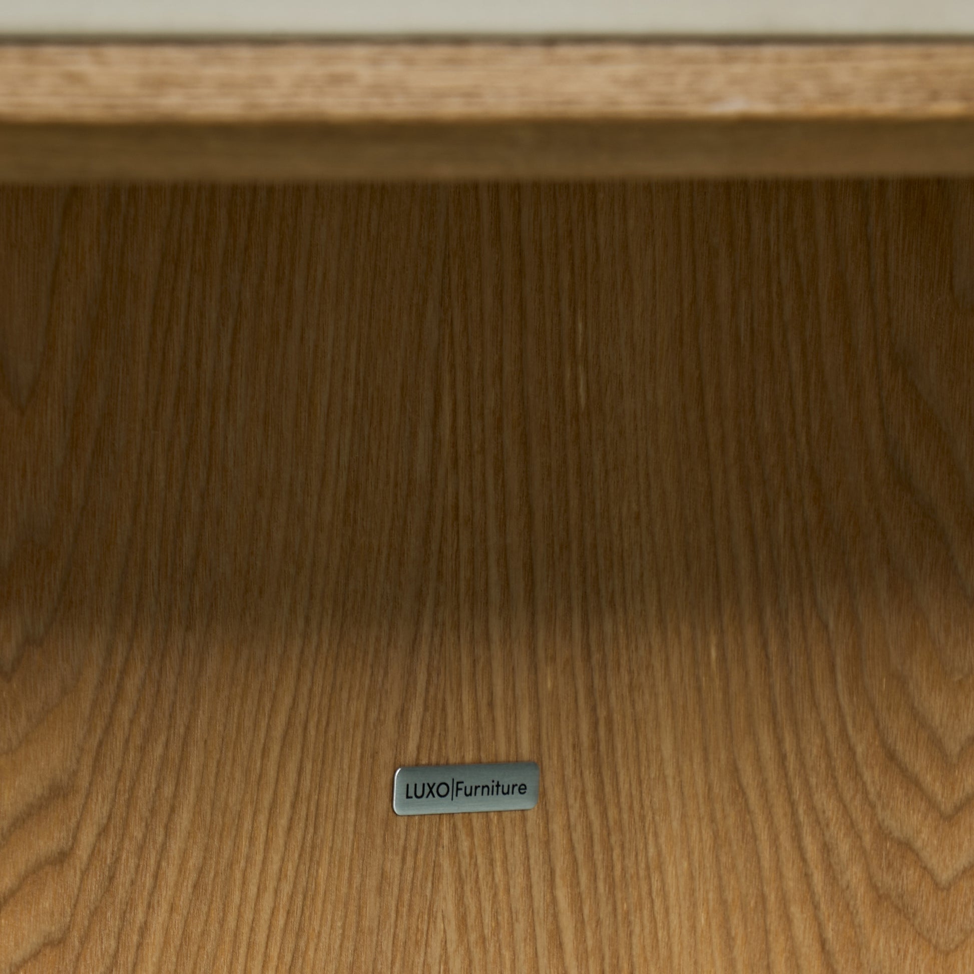 Close-up of wooden furniture surface with a LUXO Furniture label