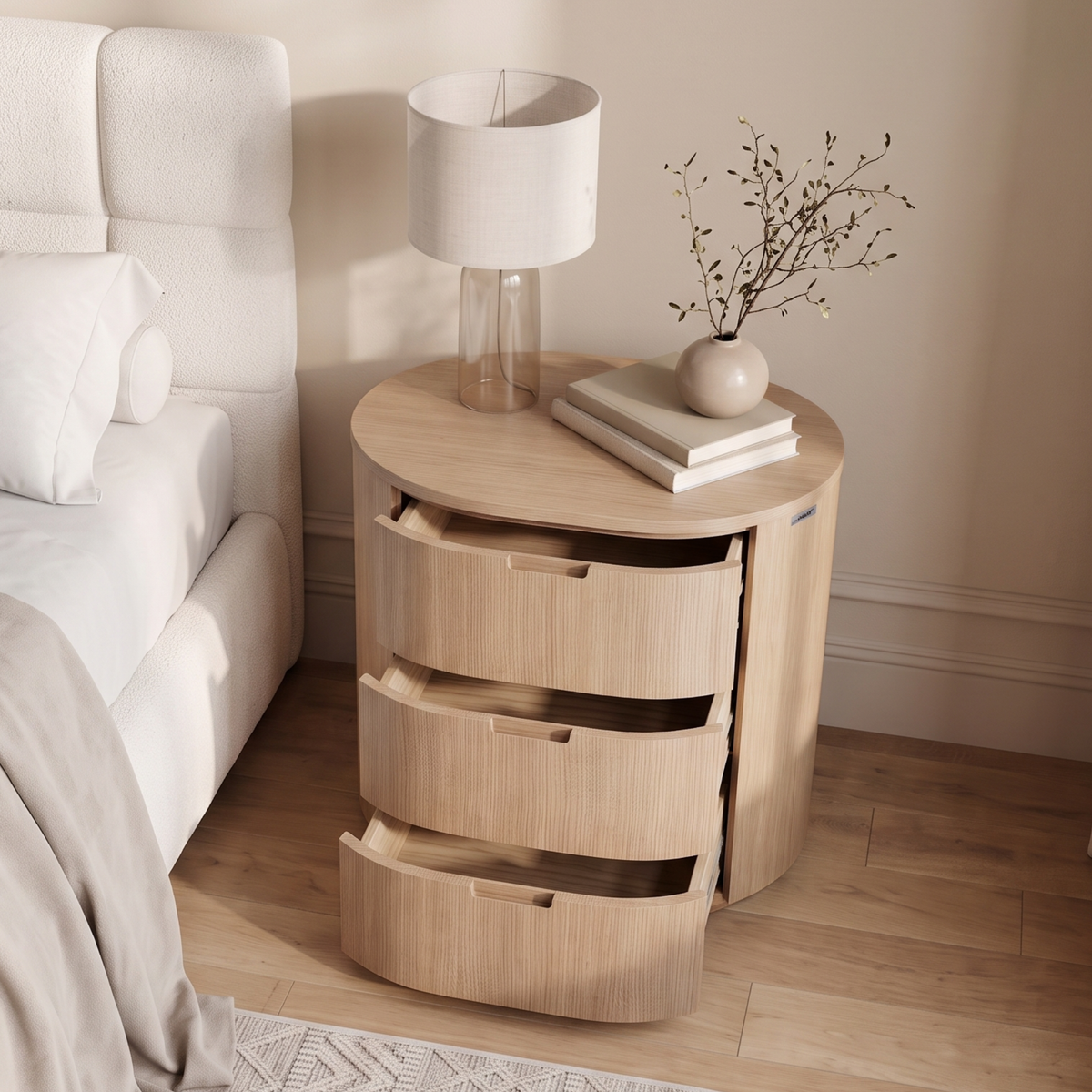 Light wood bedside table with drawers styled next to a bed in a bright bedroom