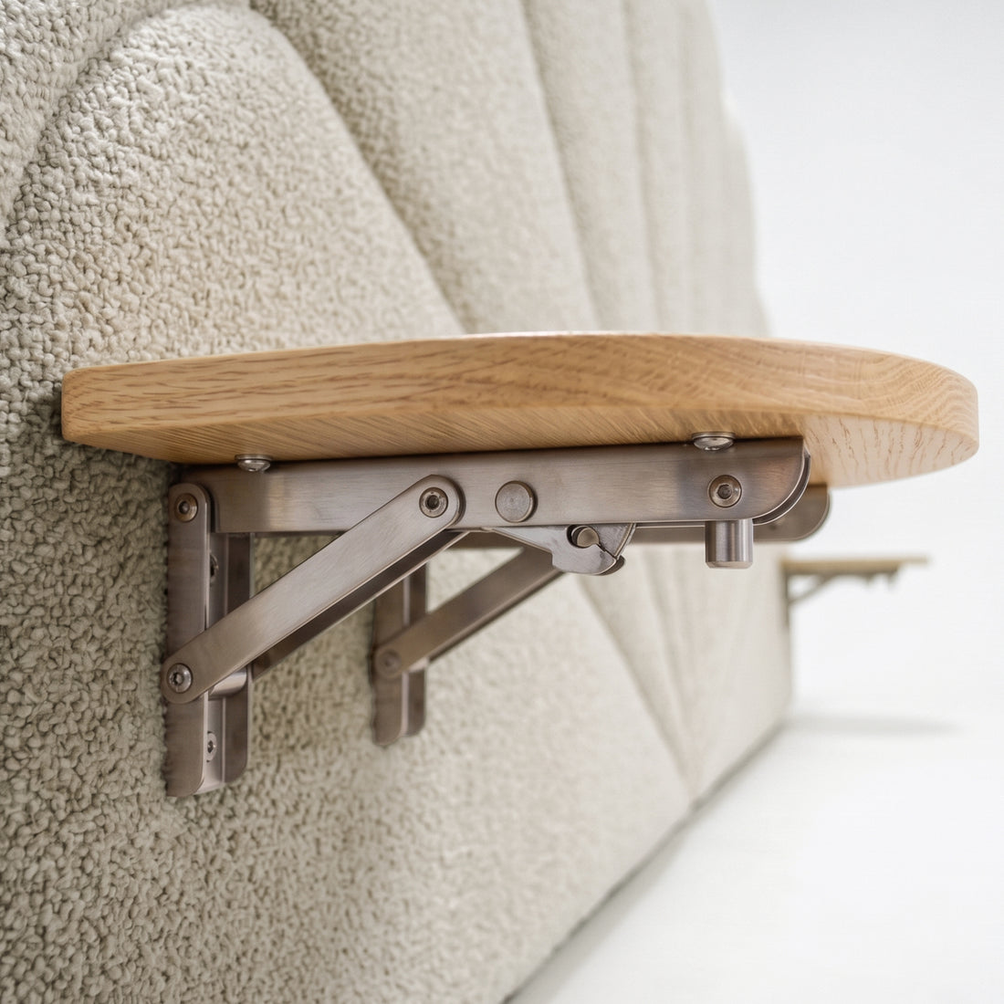 Close-up of fold-down wooden shelf and bracket attached to upholstered headboard in situ