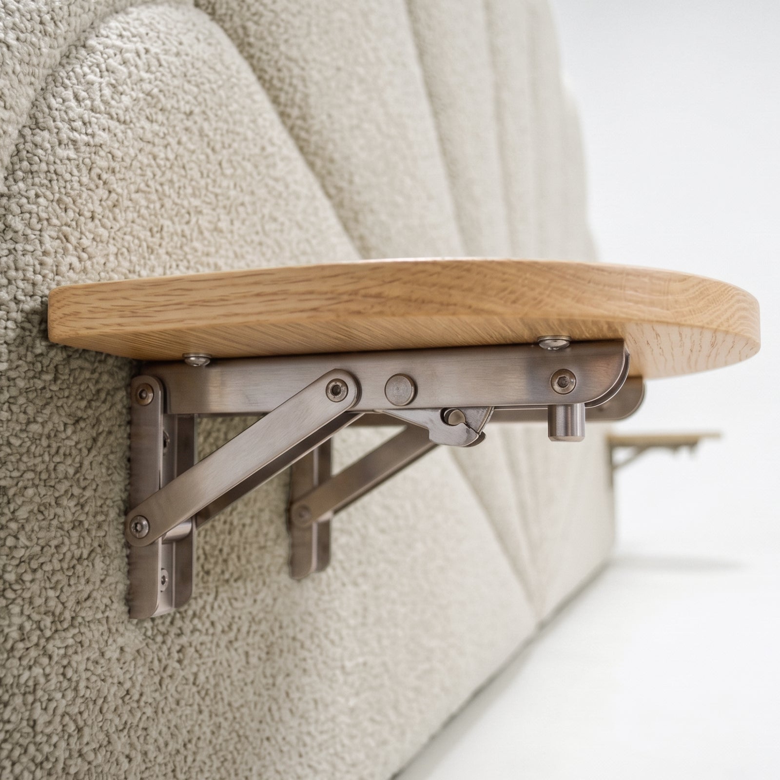 Close-up of fold-down wooden shelf and bracket attached to upholstered headboard in situ