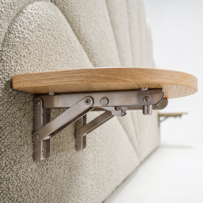 Close-up of fold-down wooden shelf and bracket attached to upholstered headboard in situ