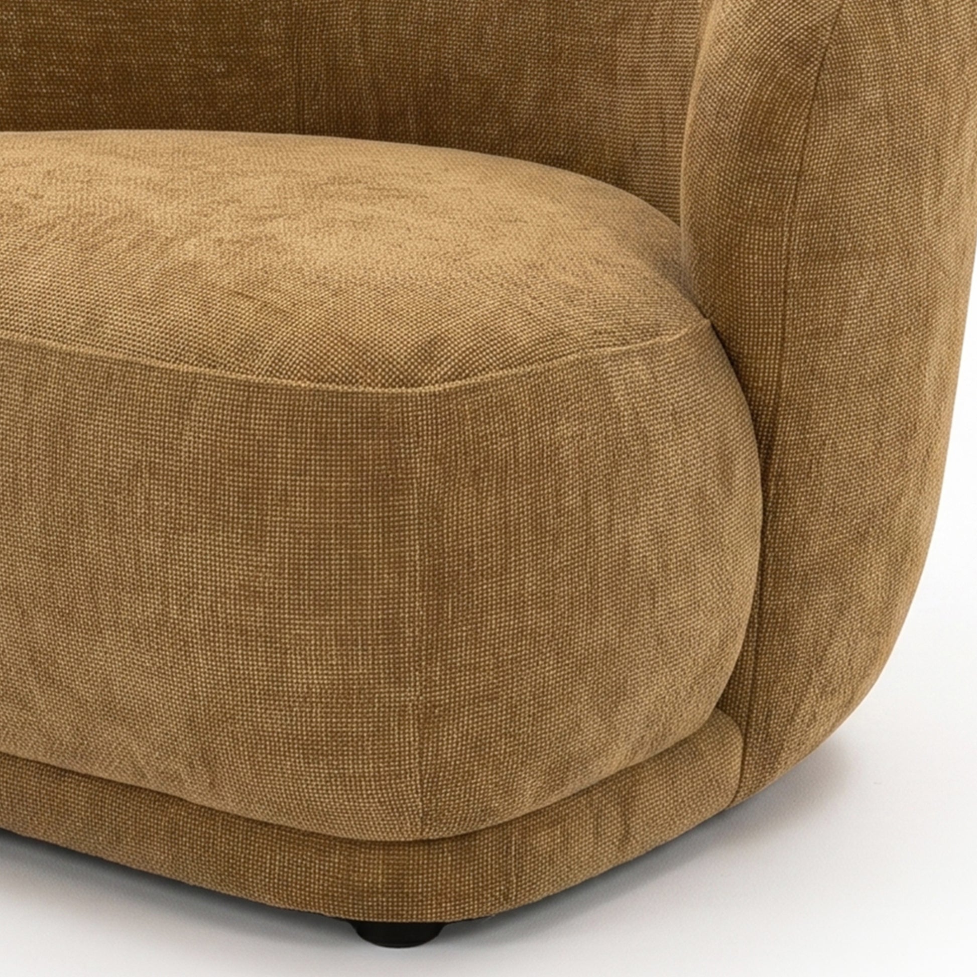 Close-up of the lower side section of a textured mustard gold upholstered chair on a white background.