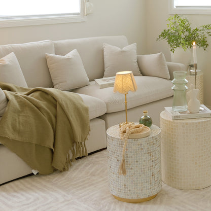 Cream sectional sofa with decorative round side tables in a cozy living room