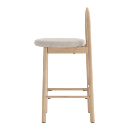 Side view of a modern upholstered stool with light wood frame on white background