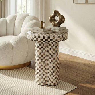 Checkered side table in a styled living room with accent chair and decorative objects