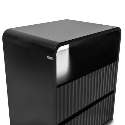 Modern black storage unit with rounded top and grooved lower section on white background