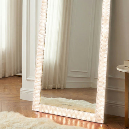 Full-length mirror with decorative frame in a bright styled room
