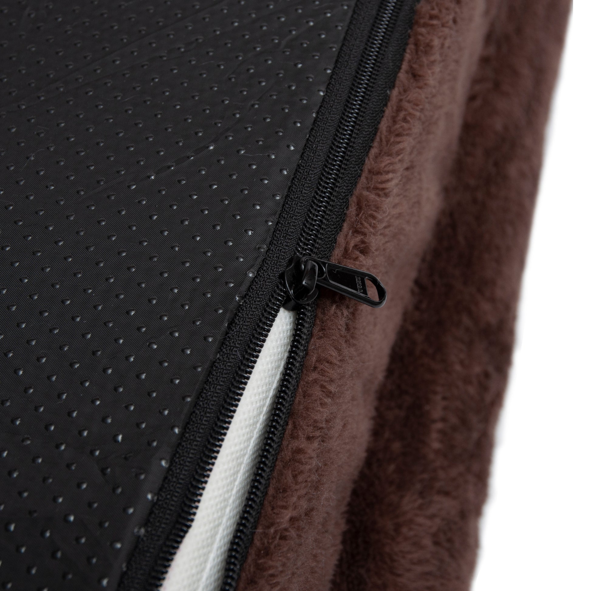 Close-up of brown fabric and zipper detail against white background